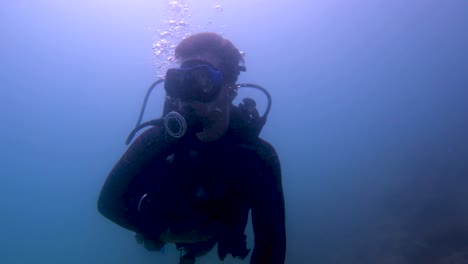 a man swims alone under the ocean water while scuba diving in mexico