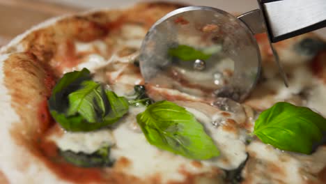 Slicing-a-hot-and-delicous-homemade-neapolitan-pizza-with-basil-and-olives