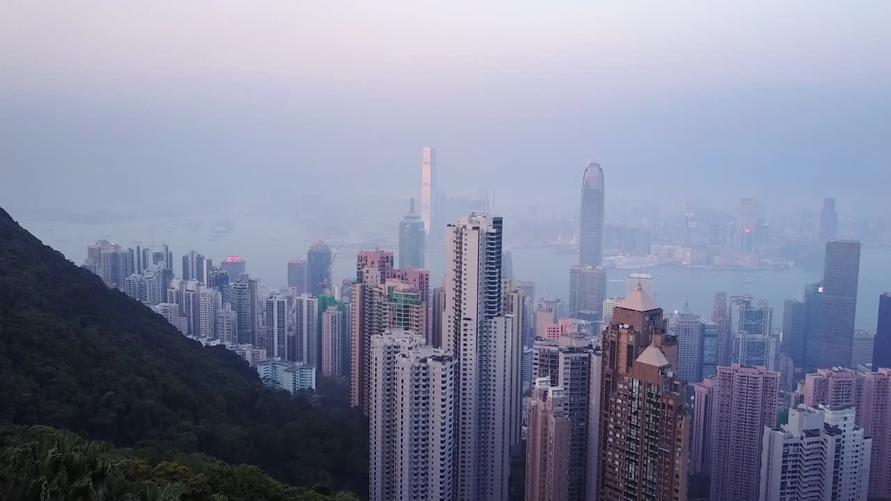 Luftfoto af Hongkongs bybillede fra udsigtspunktet The Peak ved en diset solopgang.