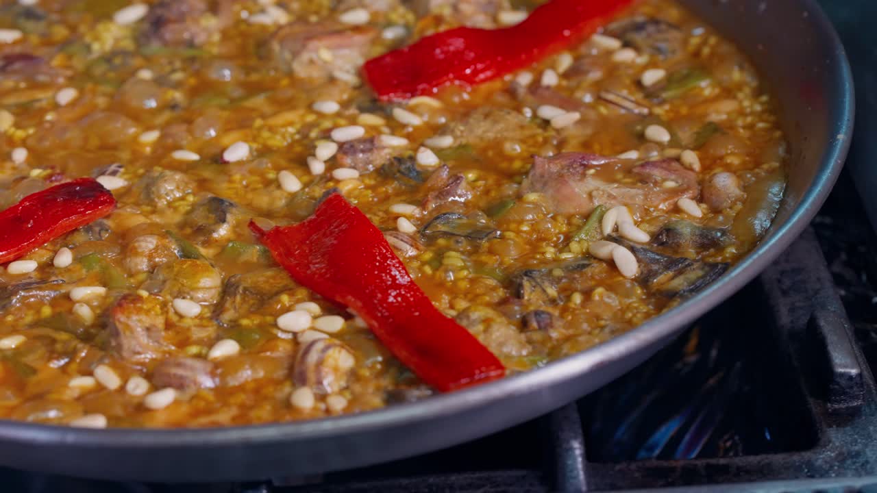 Putting red peppers in Spanish paella