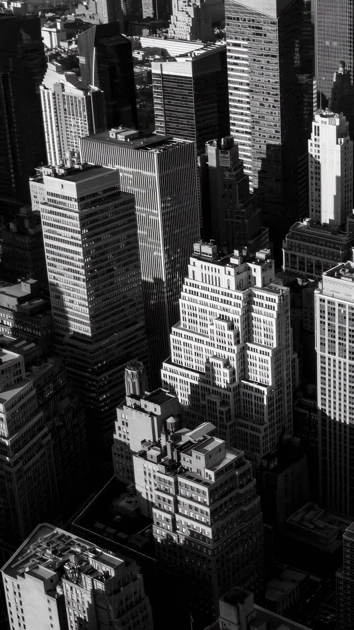Vista aérea de rascacielos en blanco y negro, capturando la densidad urbana y las sombras.