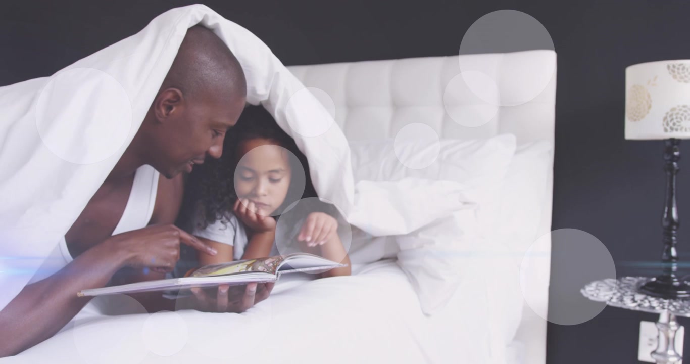 Father Reading a Book to His Daughter in Bed