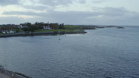 ascending aerial pullback revealing kinvara town and bay