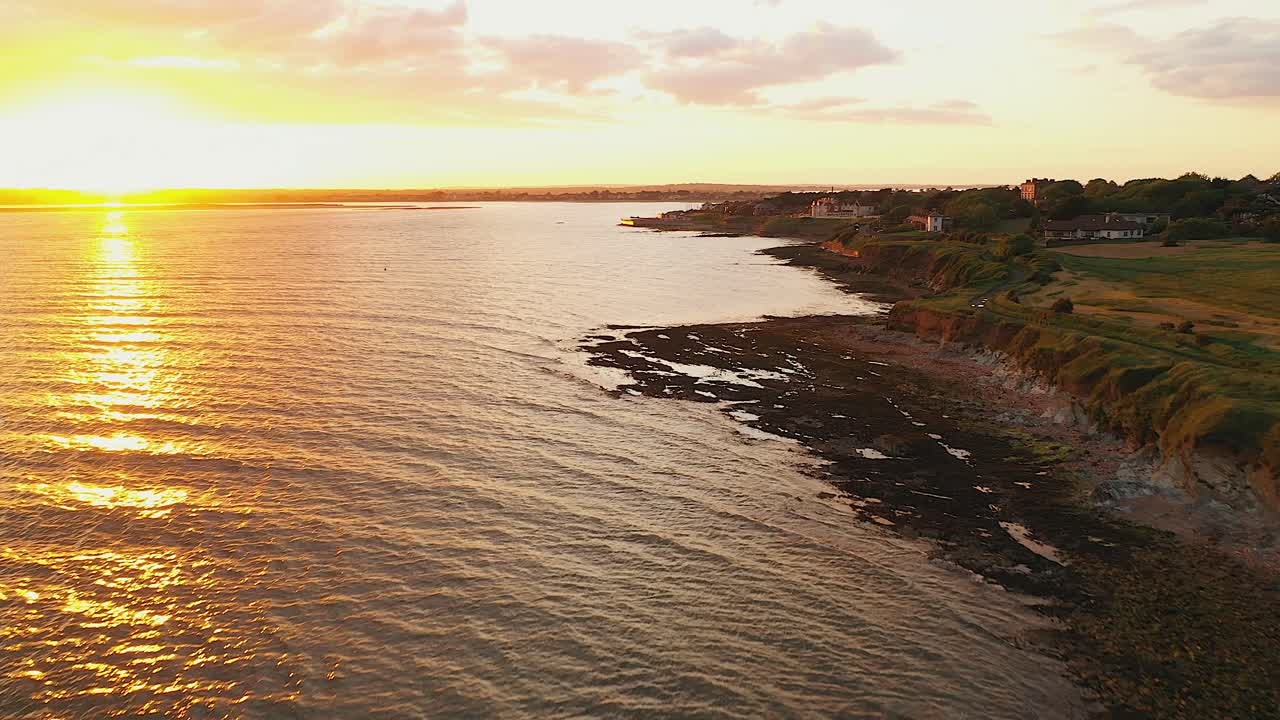 Ripresa aerea a bassa quota, tramonto estivo lungo la costa con colori meravigliosi
