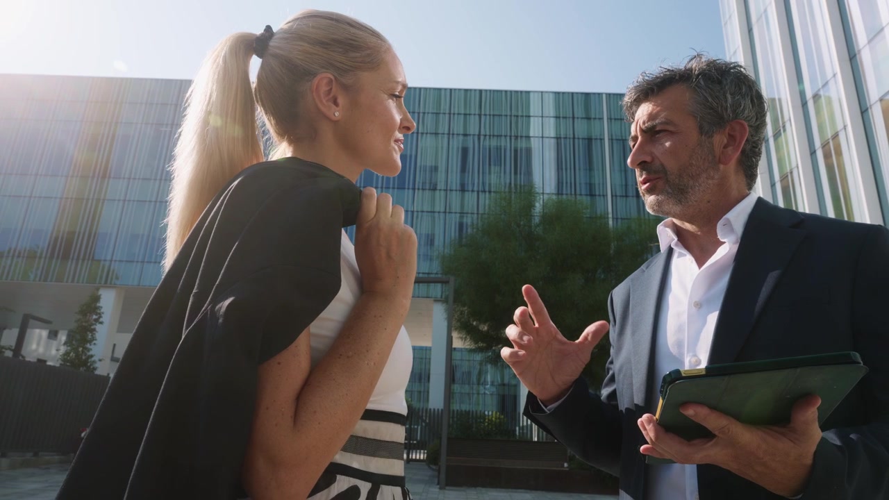 Professionisti d'affari che discutono del lavoro fuori da un moderno edificio per uffici