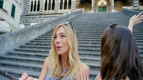 two happy women taking a selfie on stairs