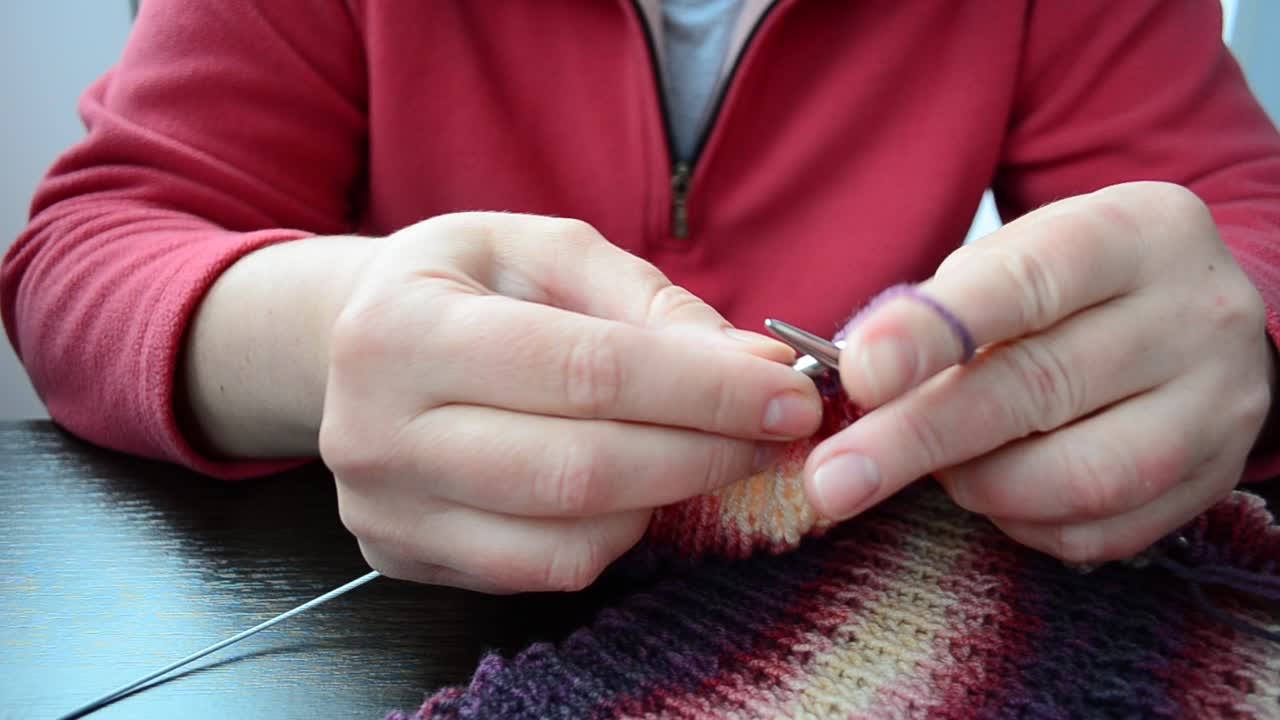 Processo di lavorazione a maglia di una sciarpa. Ferri da maglia per sciarpe.