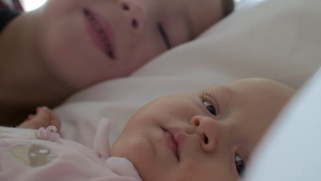 a boy kissing his baby sister on the cheek