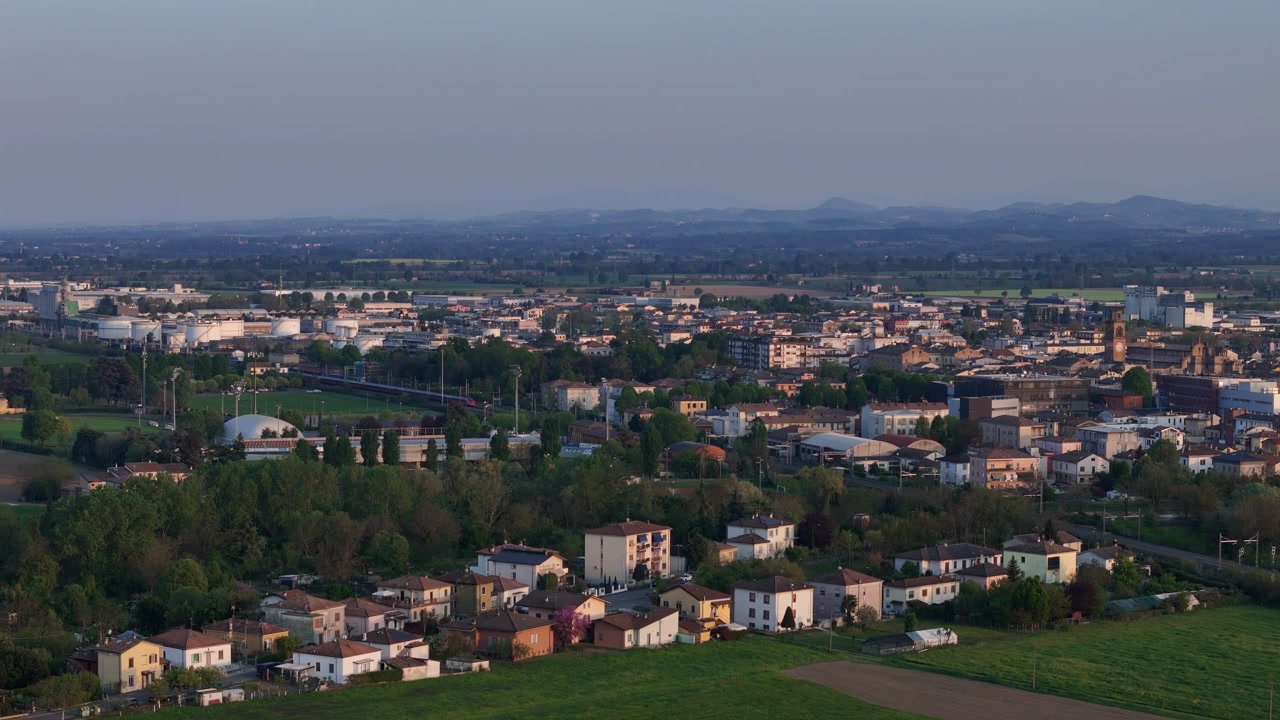 Paisaje urbano de Fiorenzuola d’Arda con edificios residenciales y trama urbana en la provincia de Piacenza, región de Emilia-Romaña, Italia, Europa, dentro de la llanura del valle del Arda y los distantes Apeninos bajo una luz cálida.