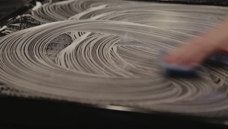 a hand cleaning the kitchen table with soap - medium shot