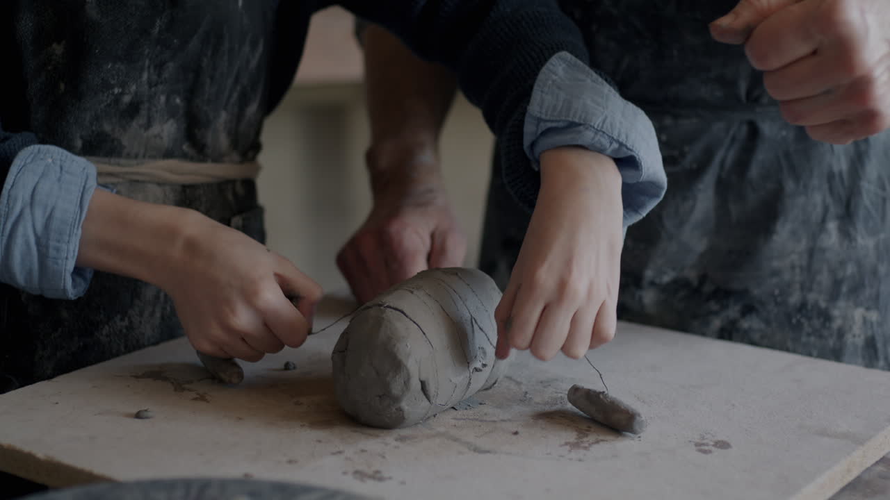 Hands Shaping Clay in Pottery Workshop
