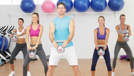 instructor de campanas de hervidor liderando una clase feliz de mujeres