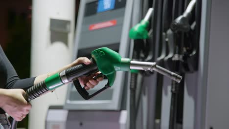 person holding a unleaded fuel handle which is out of service, because there is no petrol