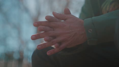 man gesturing with hands in conversation outdoors during sunset, close-up shot