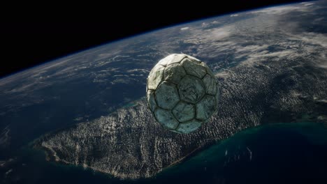 old soccer ball in space on earth orbit