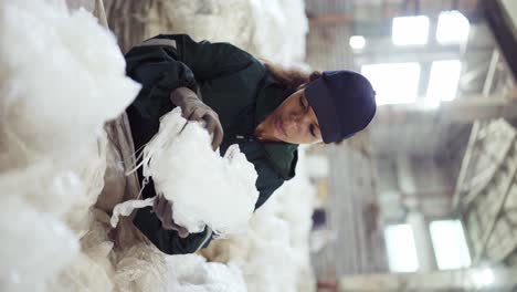 an african-american woman in a special uniform sorts polyethylene at a waste recycling plant. processing of raw materials, recycling. pollution control