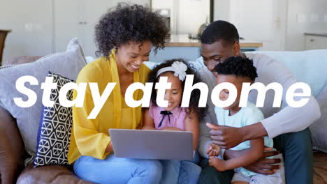 animation of stay at home text over parents with son and daughter using laptop at home