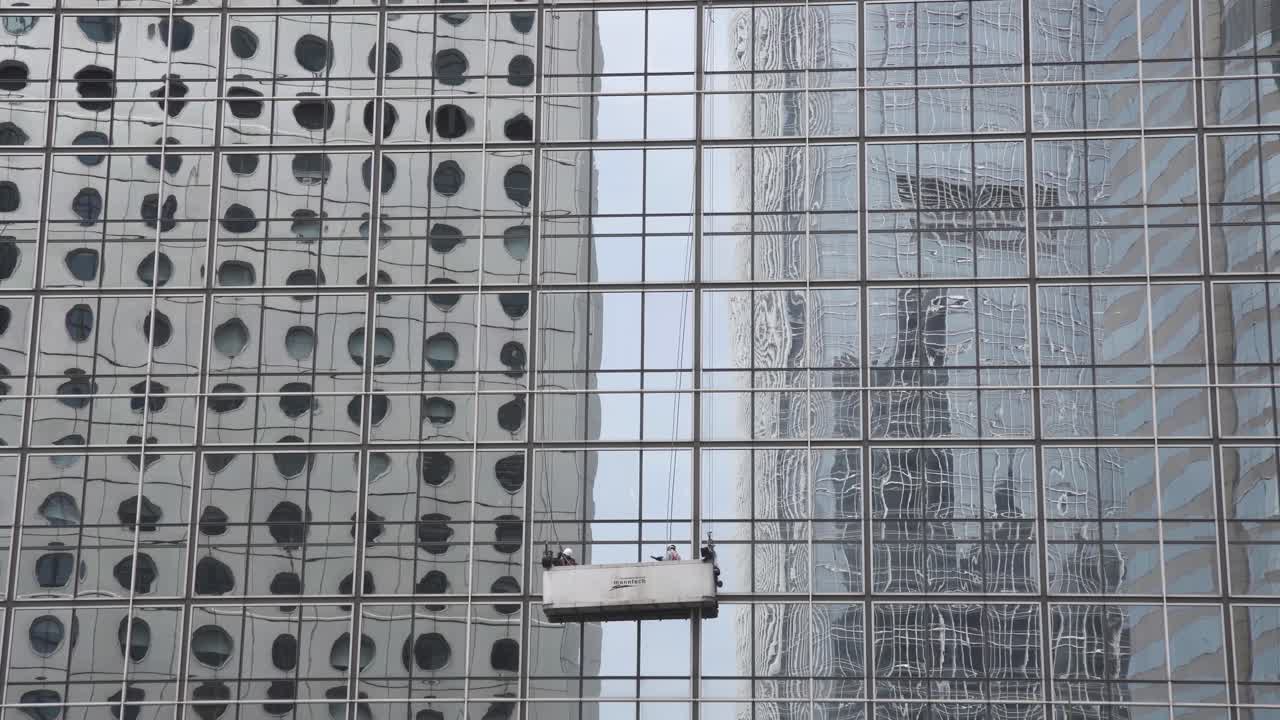 Window cleaners work on the facade of a building in Central district, Hong Kong.