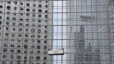 window cleaners work on the facade of a building in central district, hong kong.