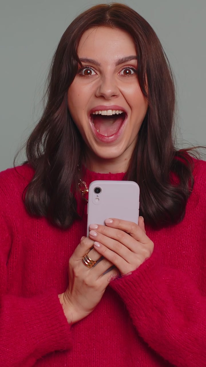 Felice donna eccitata usa il telefono cellulare dire wow sì scoperto grande grande notizia di vittoria facendo il gesto del vincitore