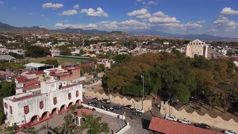 Aerial: cityscape in Oaxtepec with blue cloudy sky during the day in Morelos, Mexico, crane down drone shot