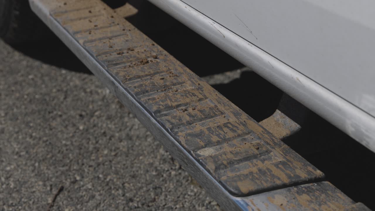 estribos embarrados en un camión blanco cubierto de barro