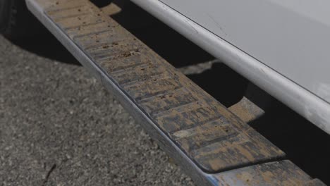 muddy running boards on a white truck covered in mud