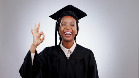 mujer negra, feliz en la graduación y el signo de ok