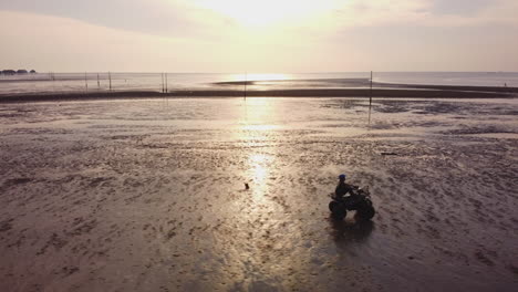 Vista-De-Drones-Siguiendo-A-Un-Ciclista-De-Atv-Montando-En-La-Playa-En-Bagan-Lalang