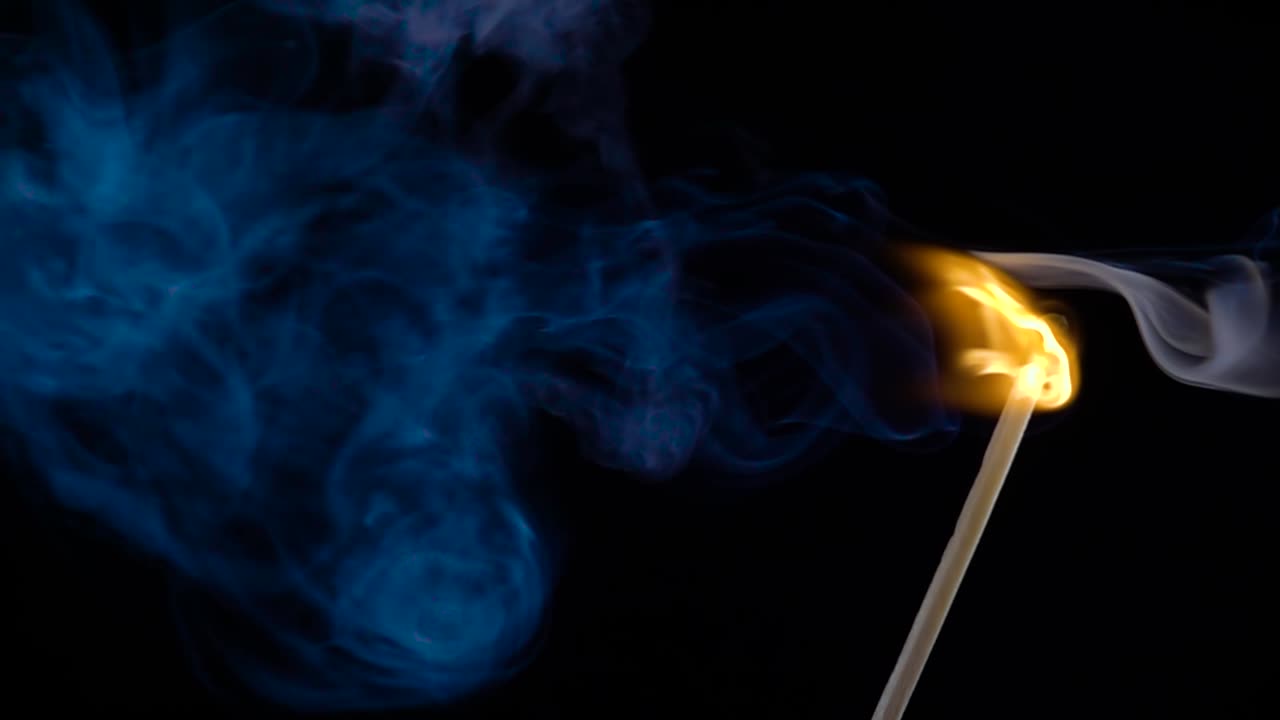 un fósforo ardiendo sobre un fondo negro en cámara lenta