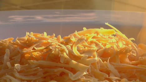 el queso rallado cae sobre los huevos revueltos humeantes