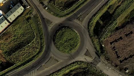 aerial : spinning rotation above roundabout as cars enter and exit