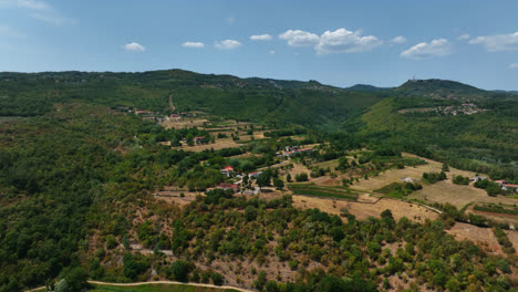 Drone-flying-around-homes-on-a-hill-in-rural-Istria,-sunny,-summer-day-in-Croatia