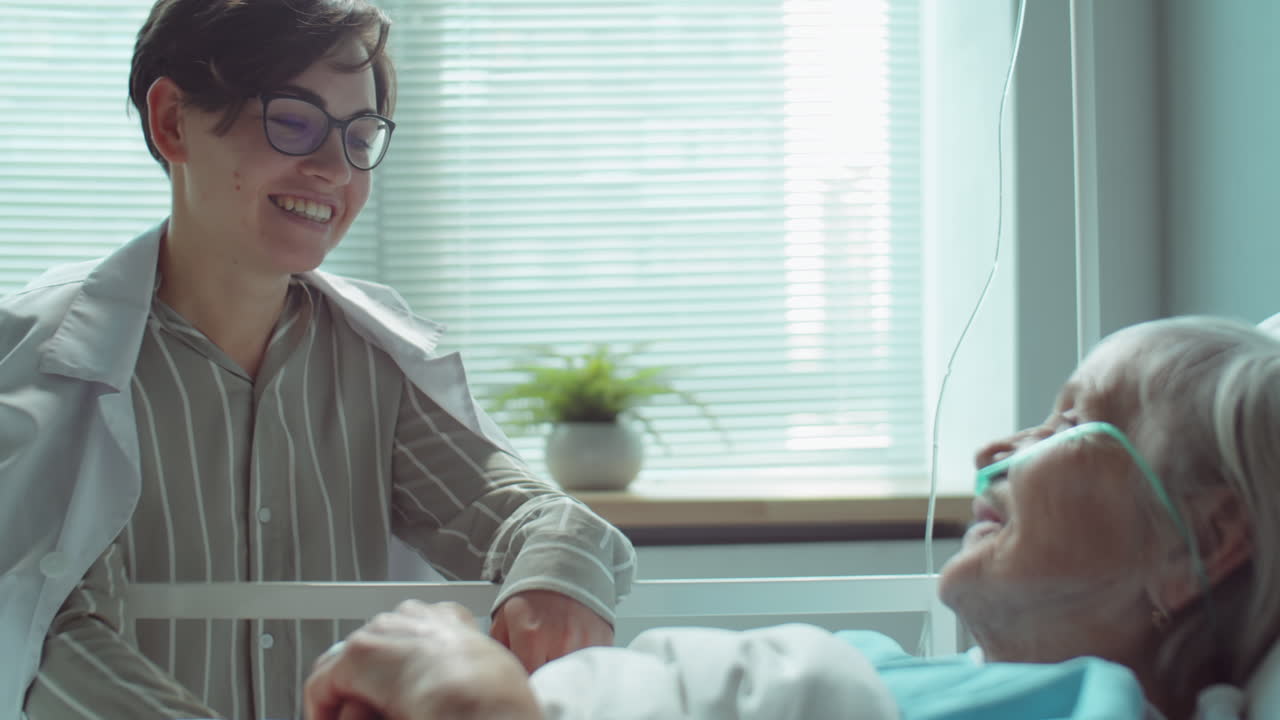 hija aplaudiendo a la madre mayor en la sala del hospital
