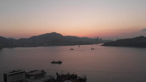 aerial, hong kong sunset in countryside. derrick barge ships in victoria harbour