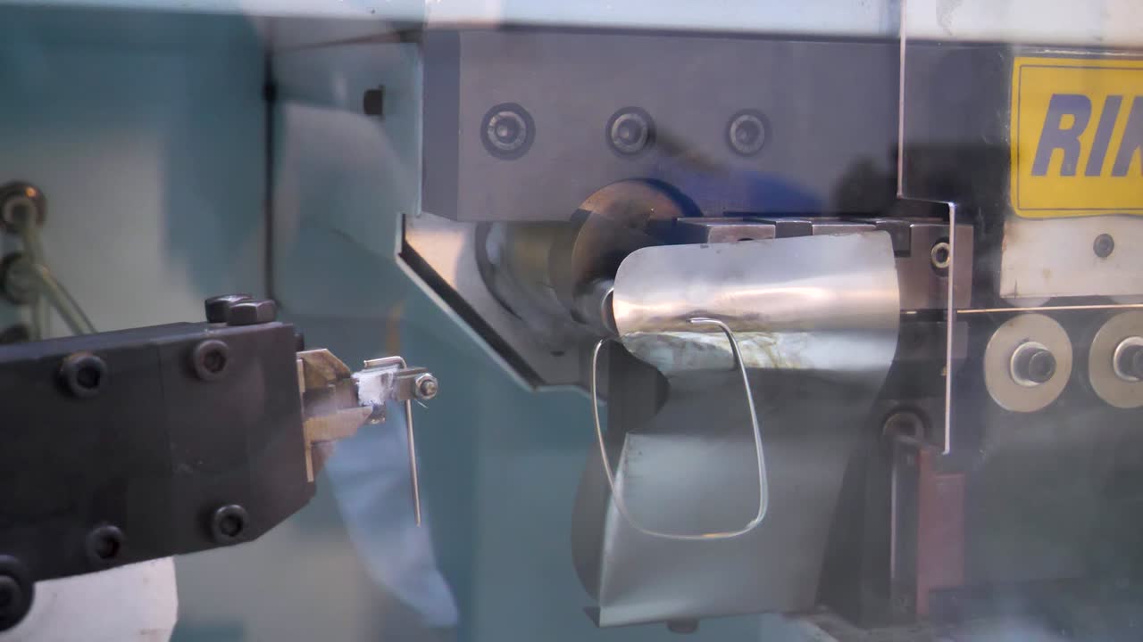 Close-up of a metal frame bending machine in a lens factory in Jiangsu Province, China, demonstrating precision and advanced manufacturing techniques.