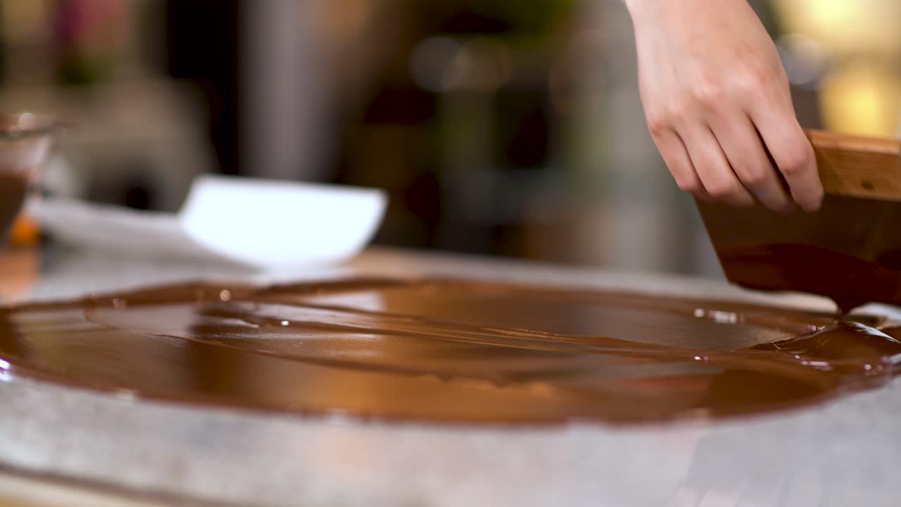 chef extendiendo ganache de chocolate con espátula