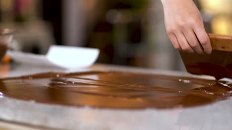 küchenchef verbreitet schokoladen-ganache mit spatel