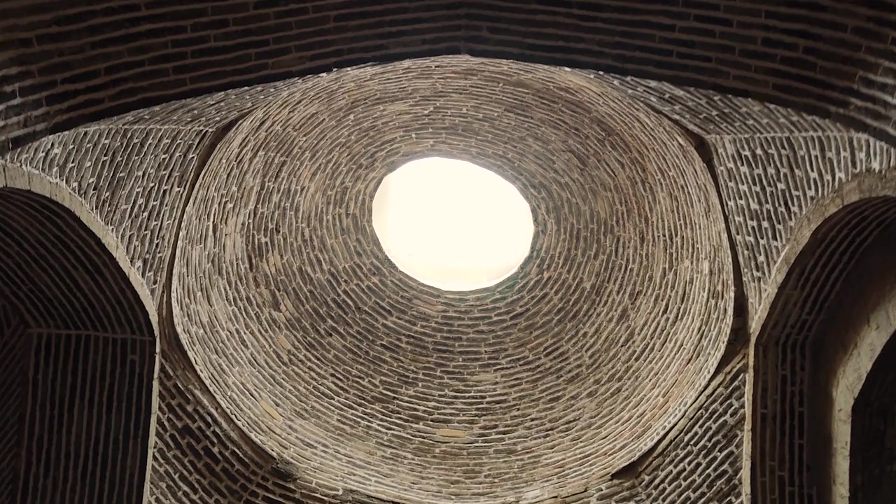 Vista dal basso di un'antica cupola in mattoni con lucernario centrale
