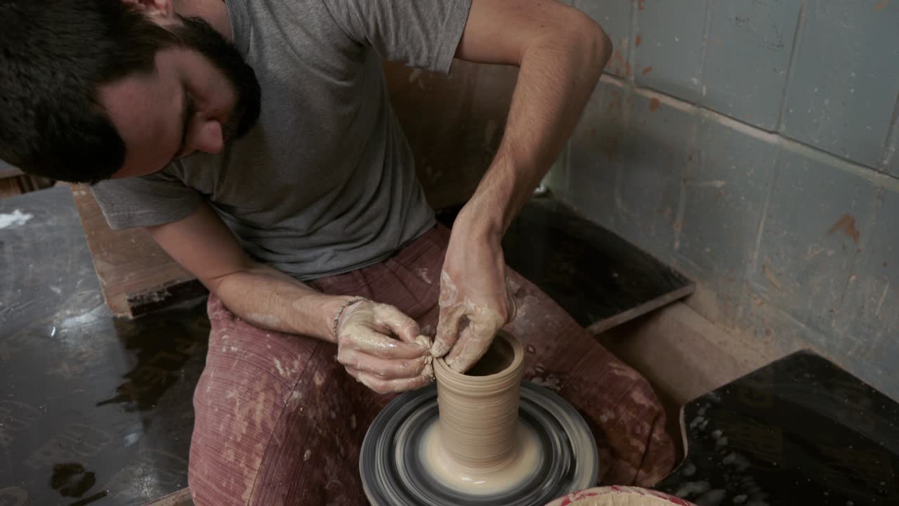 The potter makes a jug of clay. Ceramist. A man makes a vase on a potter's wheel