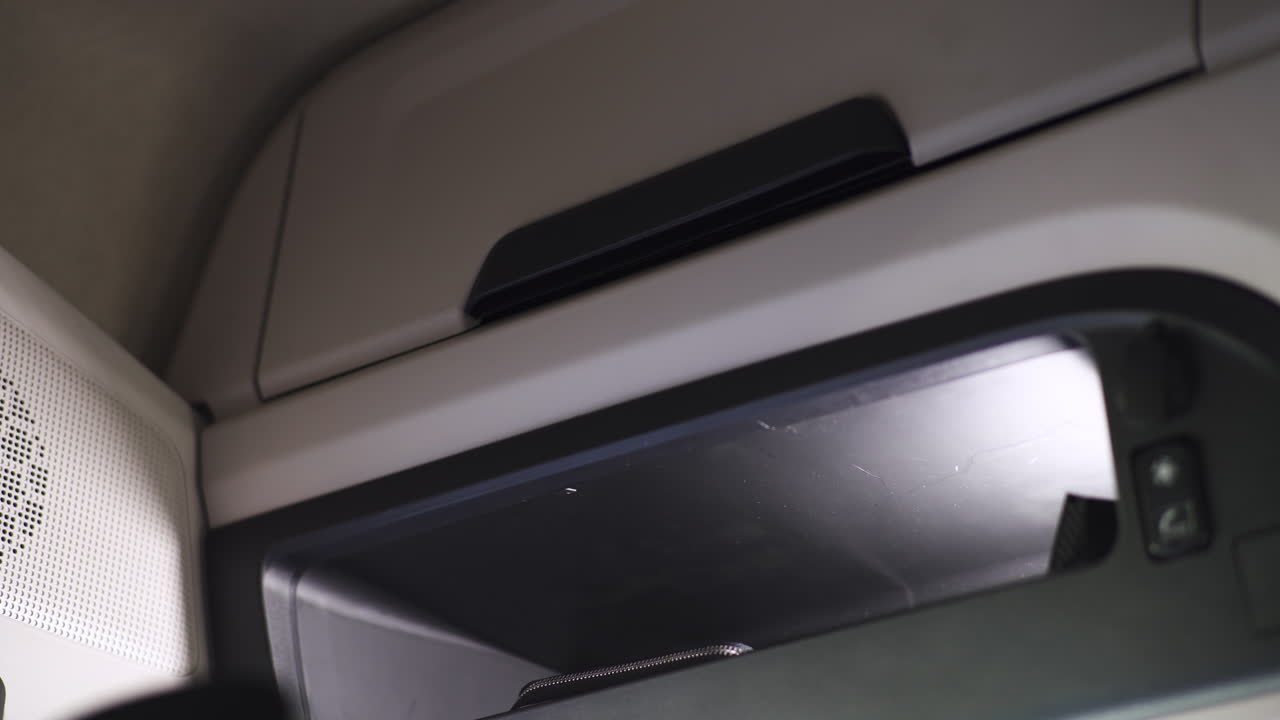 Truck Driver Placing Phone in Interior Storage