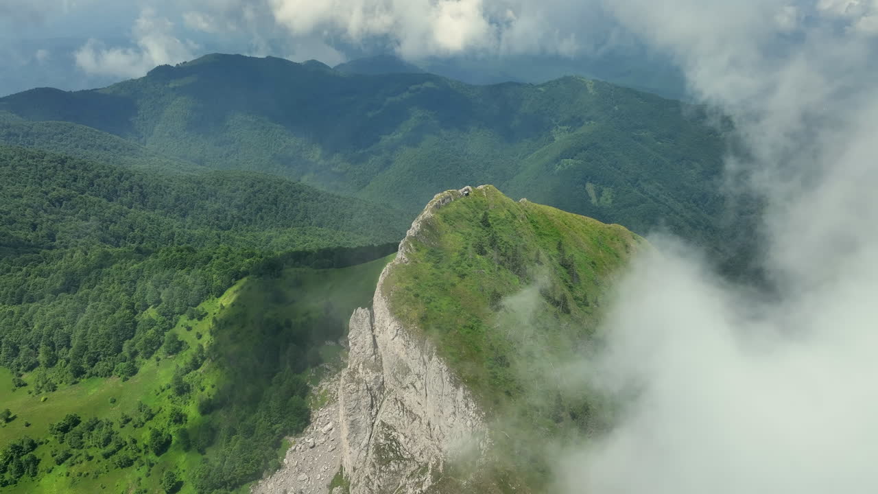 volando a través de nubes blancas y esponjosas por encima de los picos verdes de las montañas
