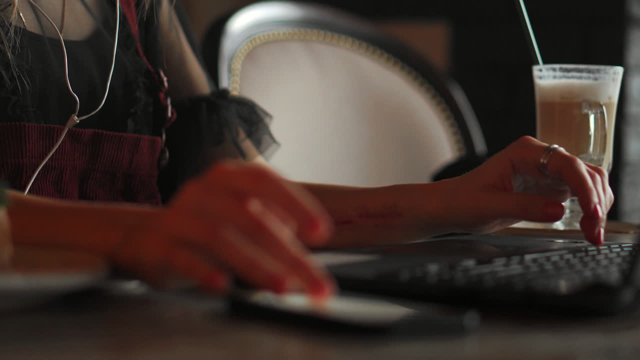 Serious senior woman helpline operator with headphones and using laptop at workplace