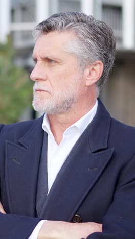profile portrait of a serious older man with gray hair and beard