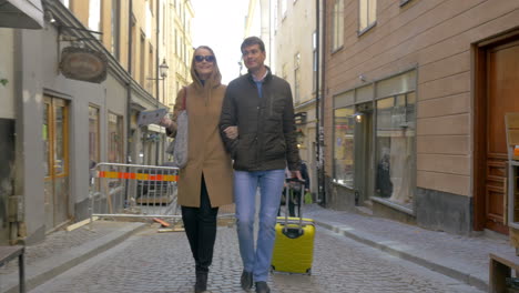 young travelers with map and bag searching the way in city