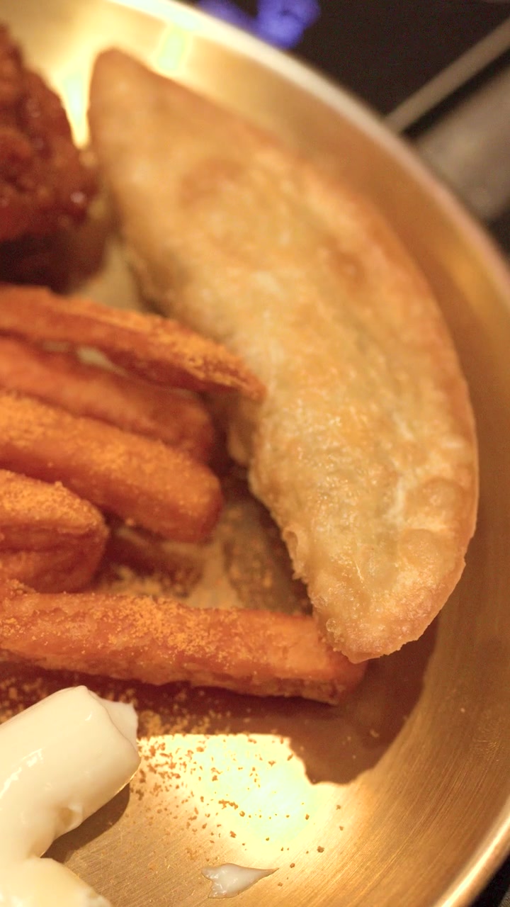 Close-up de dumplings fritos, batatas fritas temperadas e maionese servidos em um prato de latão
