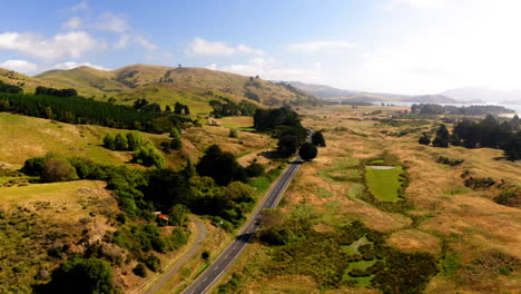 aerial view of a scenic road winding through rolling hills and rural landscape