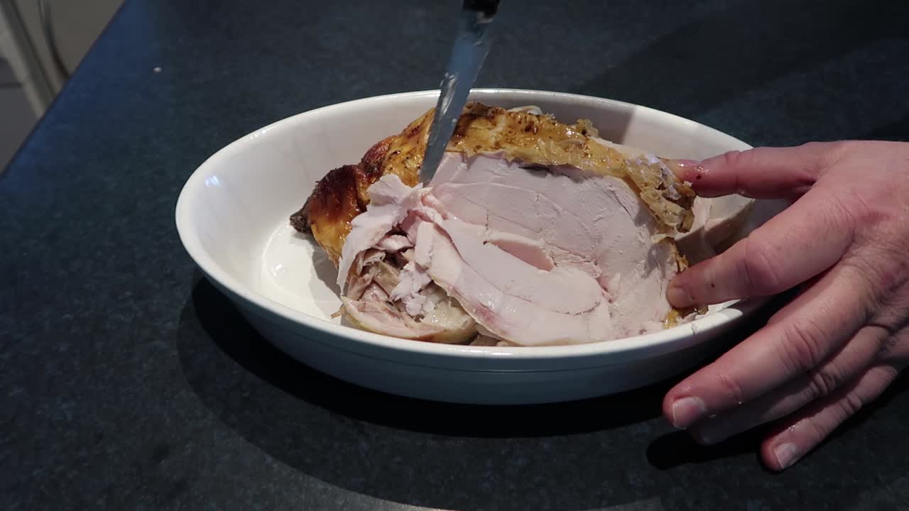 Man cutting or carving a hot roast chicken