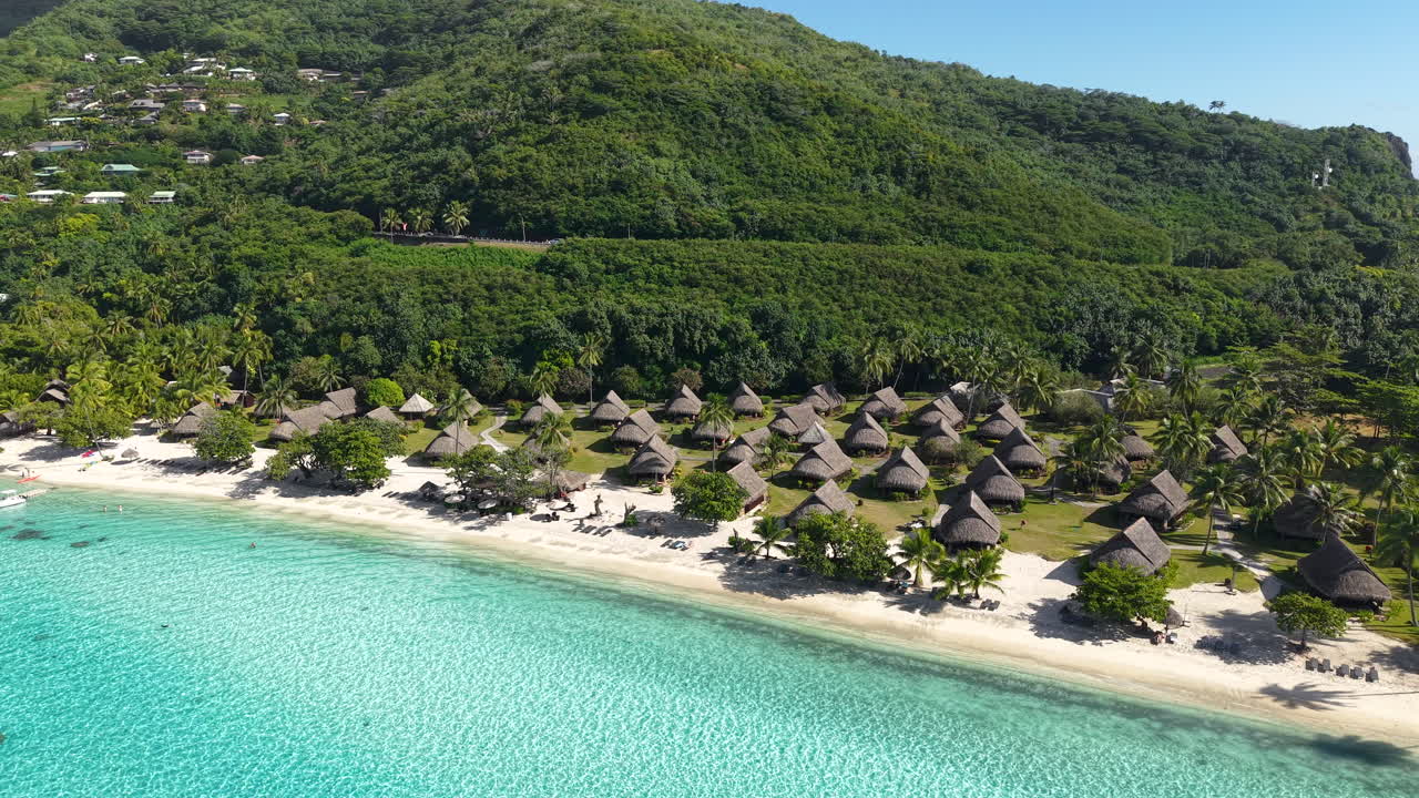 Drone Shot of Moorea, French Polynesia. Beachfront Villas, Turquoise Lagoon Water and Green Hills