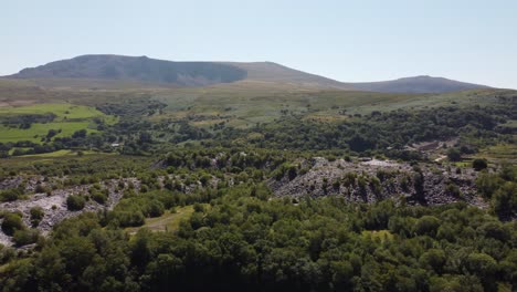 dorothea disused overgrown slate mining quarry in lush dense snowdonia mountain woodland aerial view